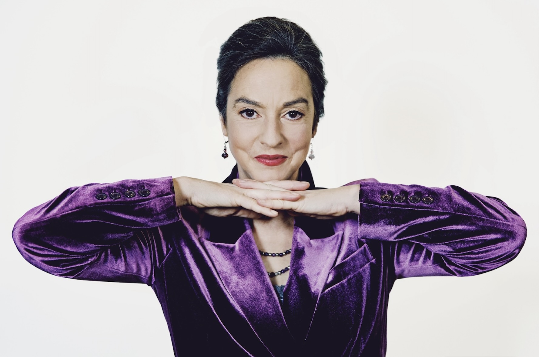 Franziska im lila Samt-Anzug vor weißem Hintergrund, Blick in die Kamera